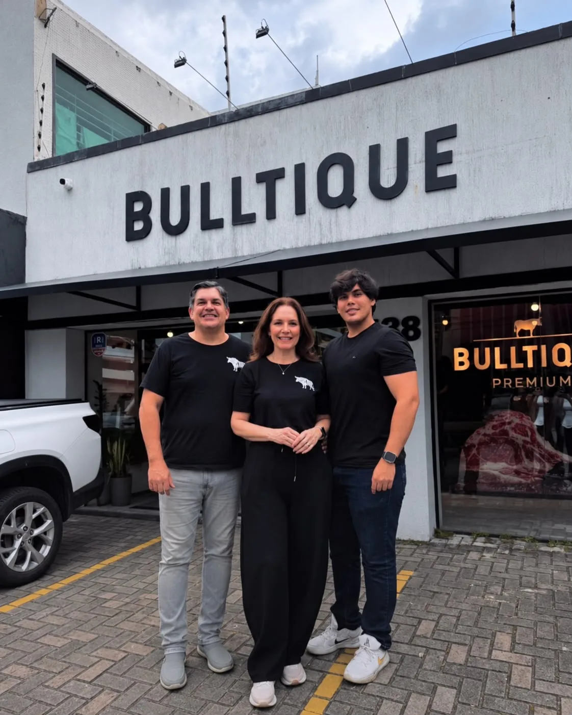 Francisco Lima e Luciana Furlaneto com a família em frente à fachada da Bulltique no Pina