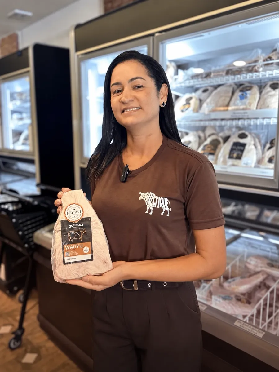 Atendente da Bulltique segurando um corte Wagyu Guidara